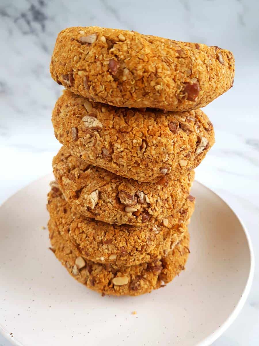 Stack of pinto bean burgers on a white plate.