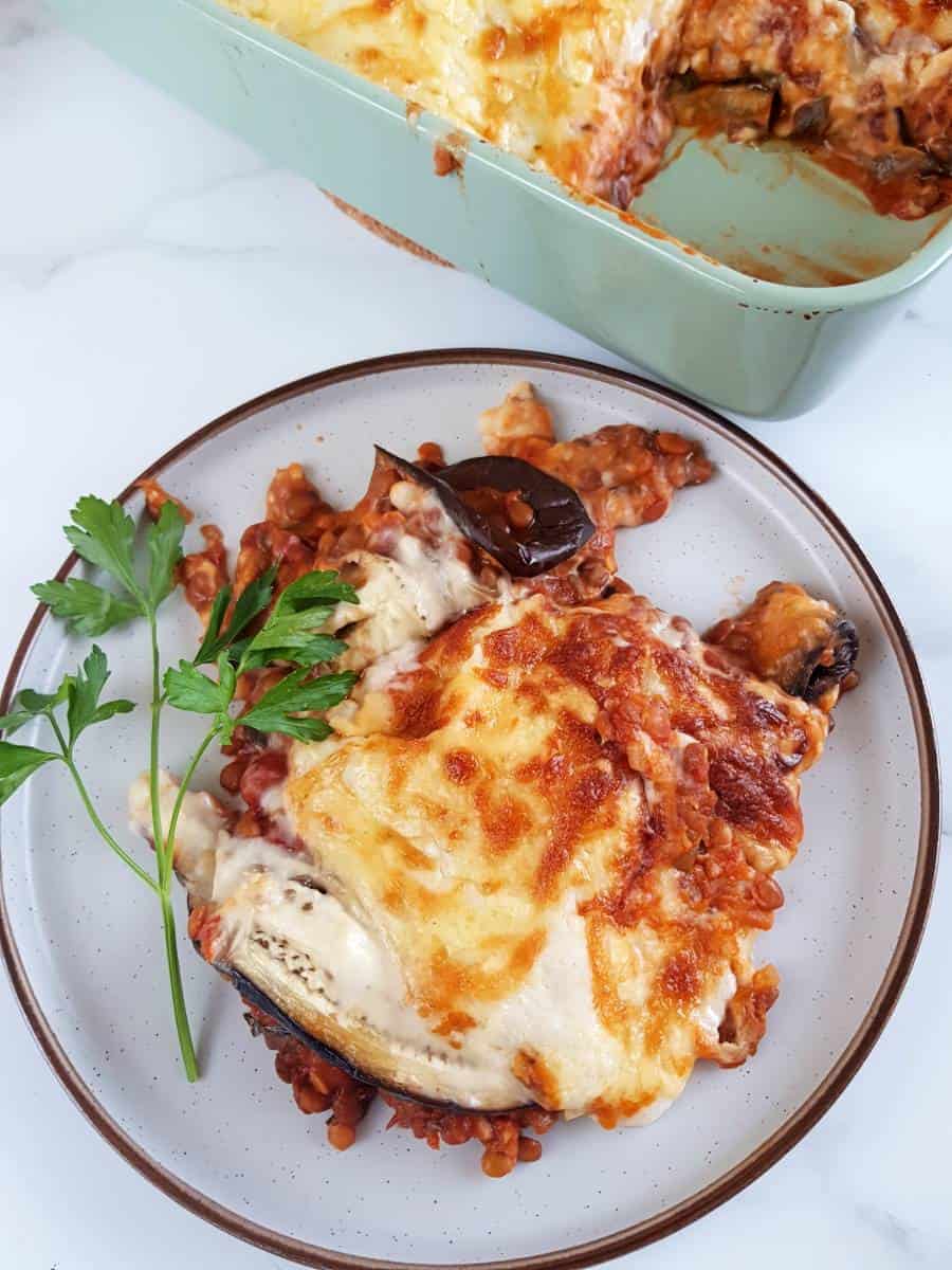 Vegetarian lentil moussaka served on a plate on a marble table.