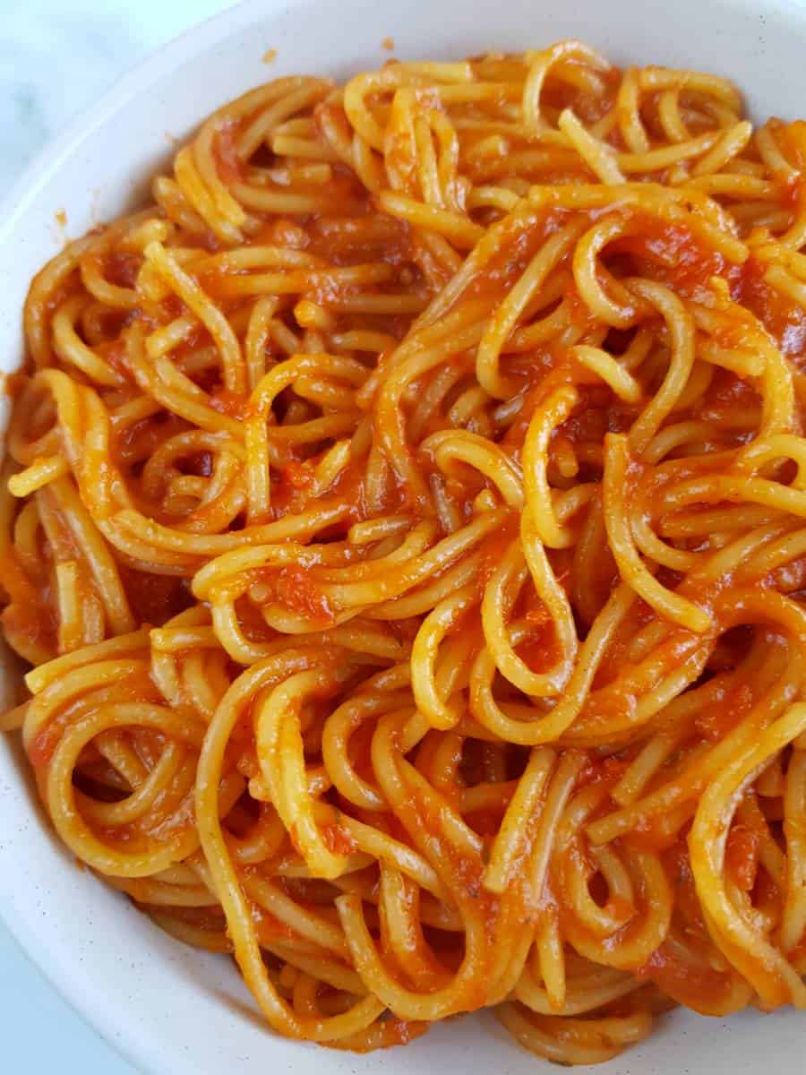 Spaghetti with jollof sauce in a bowl.