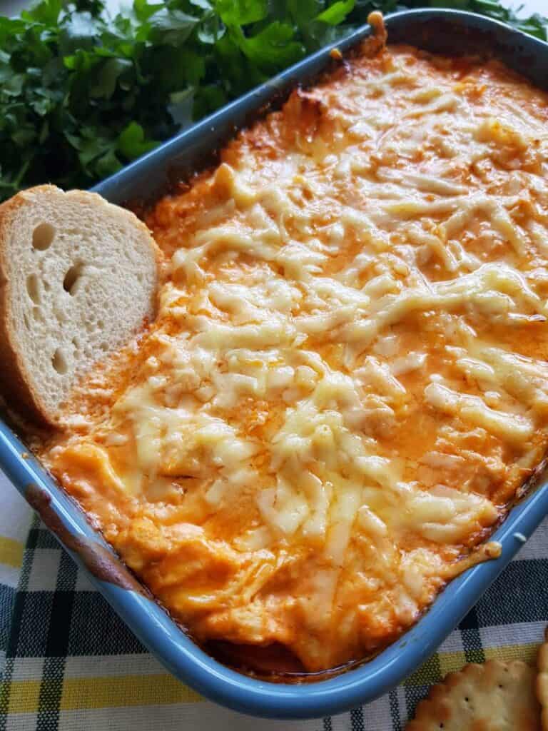 Buffalo chicken dip with a piece of baguette.