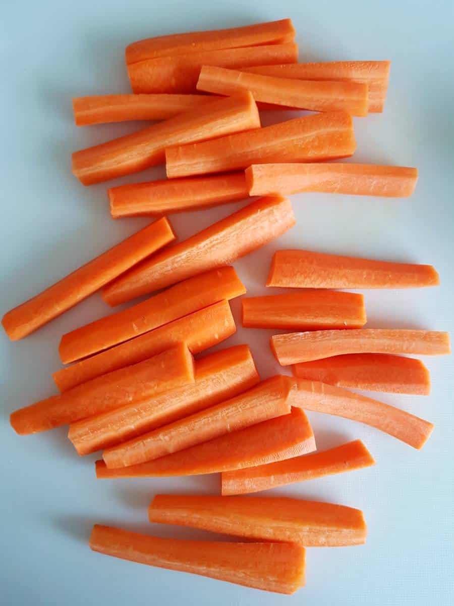 Carrot sticks on a chopping board.