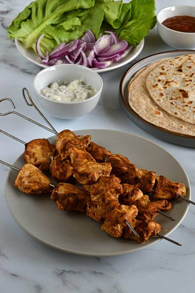 Chicken skewers tikka with salad on the side,