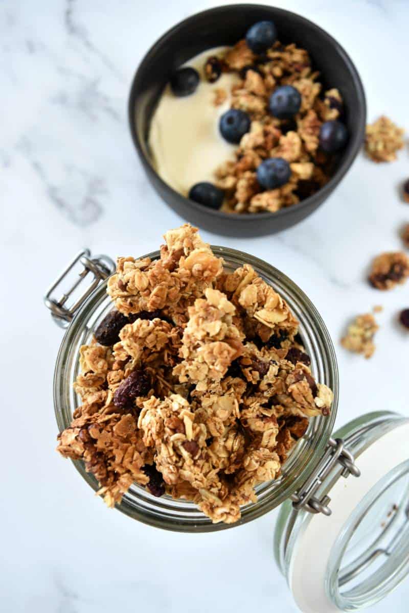 Dried blueberry granola in a mason jar on a marble table.