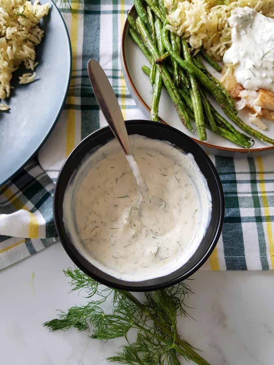 Sauce with yogurt and dill on a table.