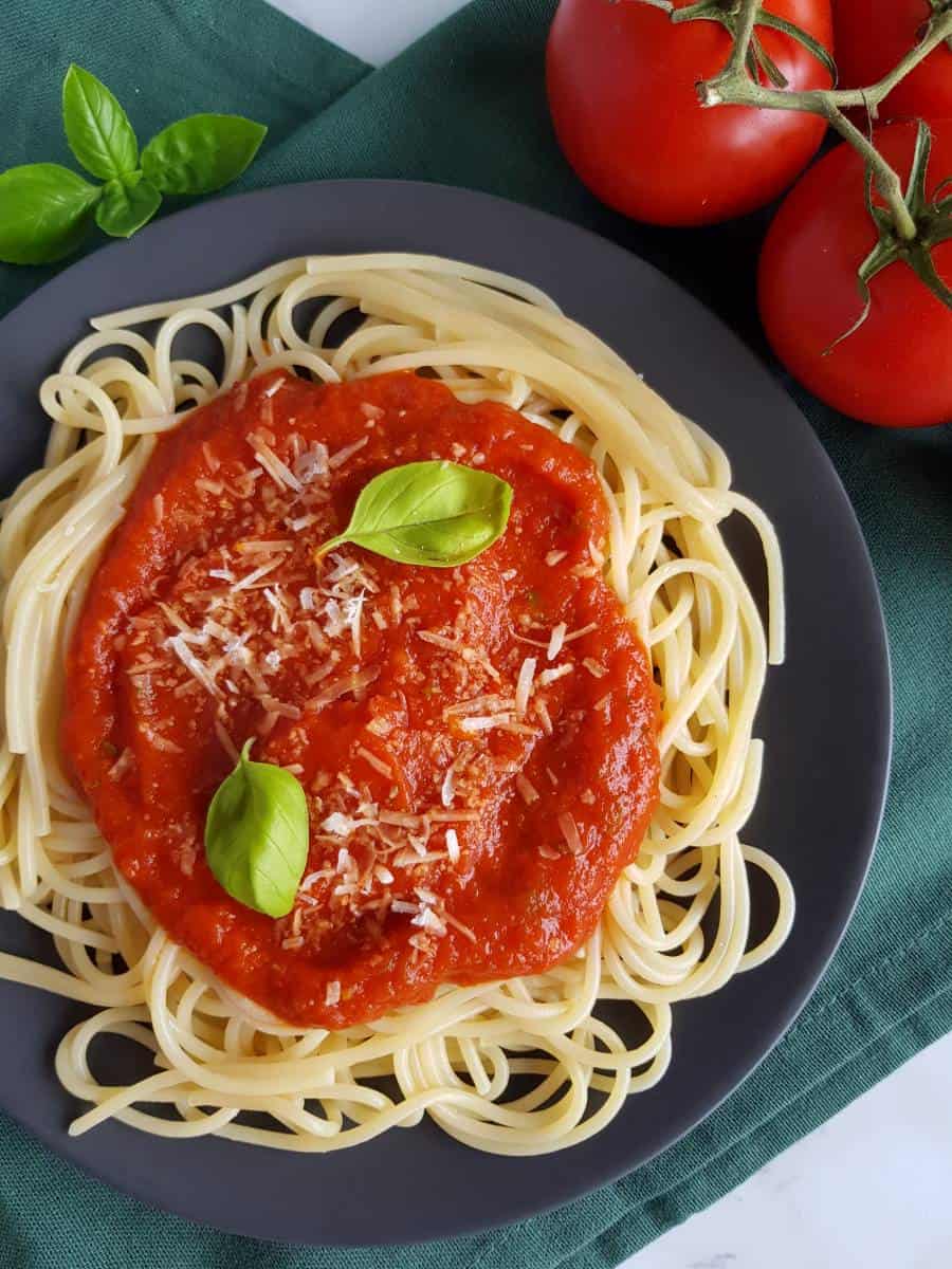 Tomato pasta sauce on pasta with basil.