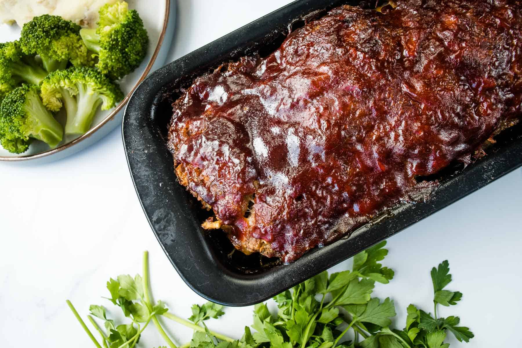 Cooked BBQ meatloaf in a loaf pan.