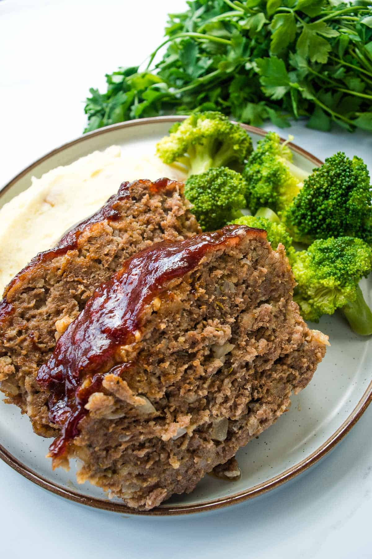 BBQ Meatloaf slices with broccoli and mashed potatoes.