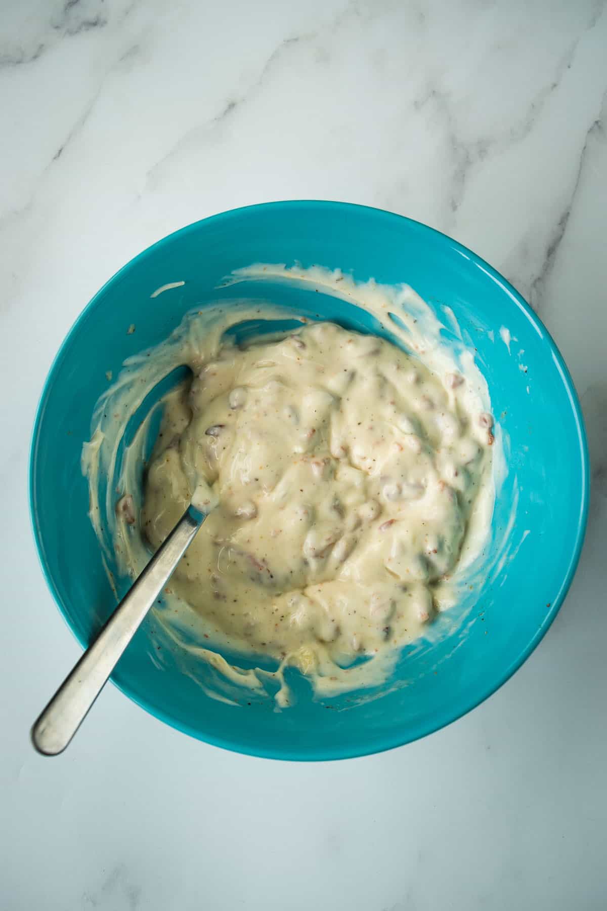 Making bacon aioli in a bowl.