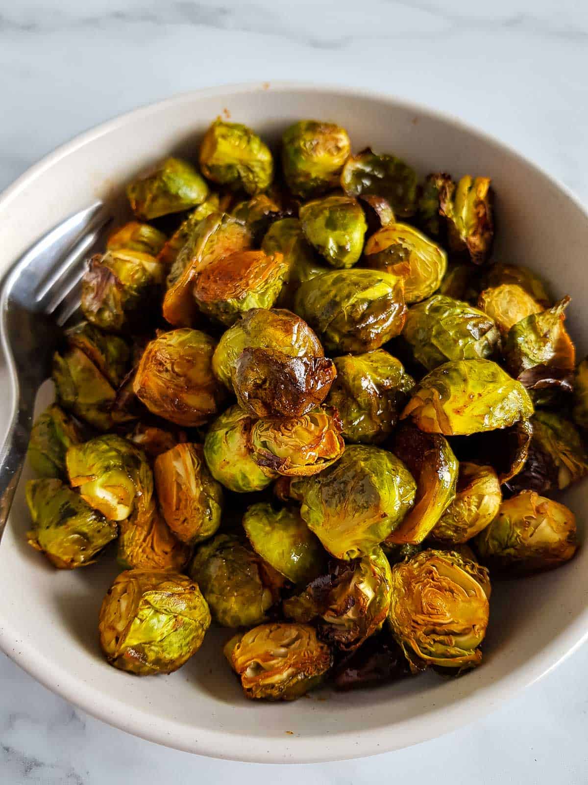 Honey Sriracha Brussels Sprouts in a bowl with a fork.