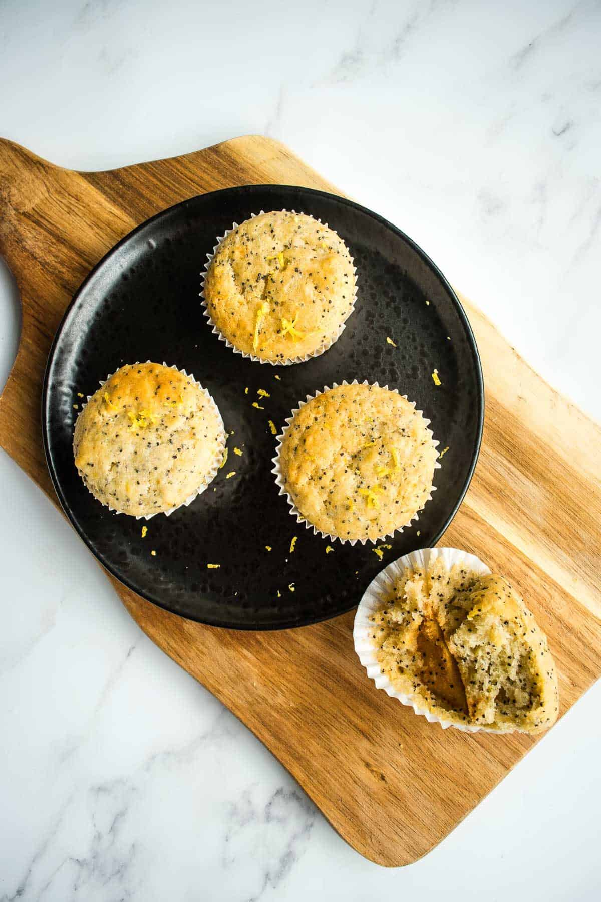 Lemon poppy seed muffins on a chopping board.