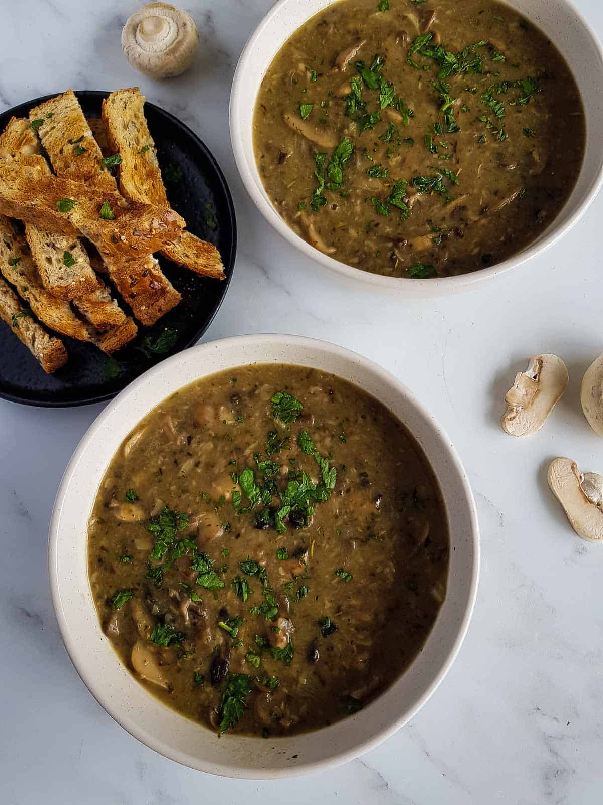 Button mushroom soup in bowls.