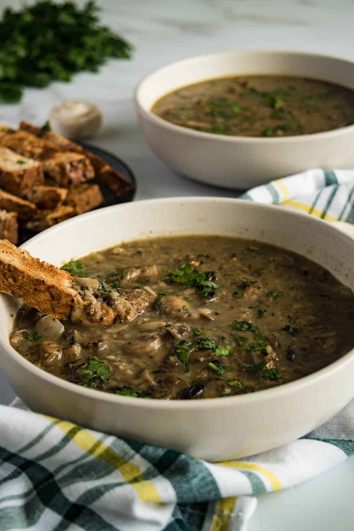 Mushroom soup with a stick of toasted bread dipped in.