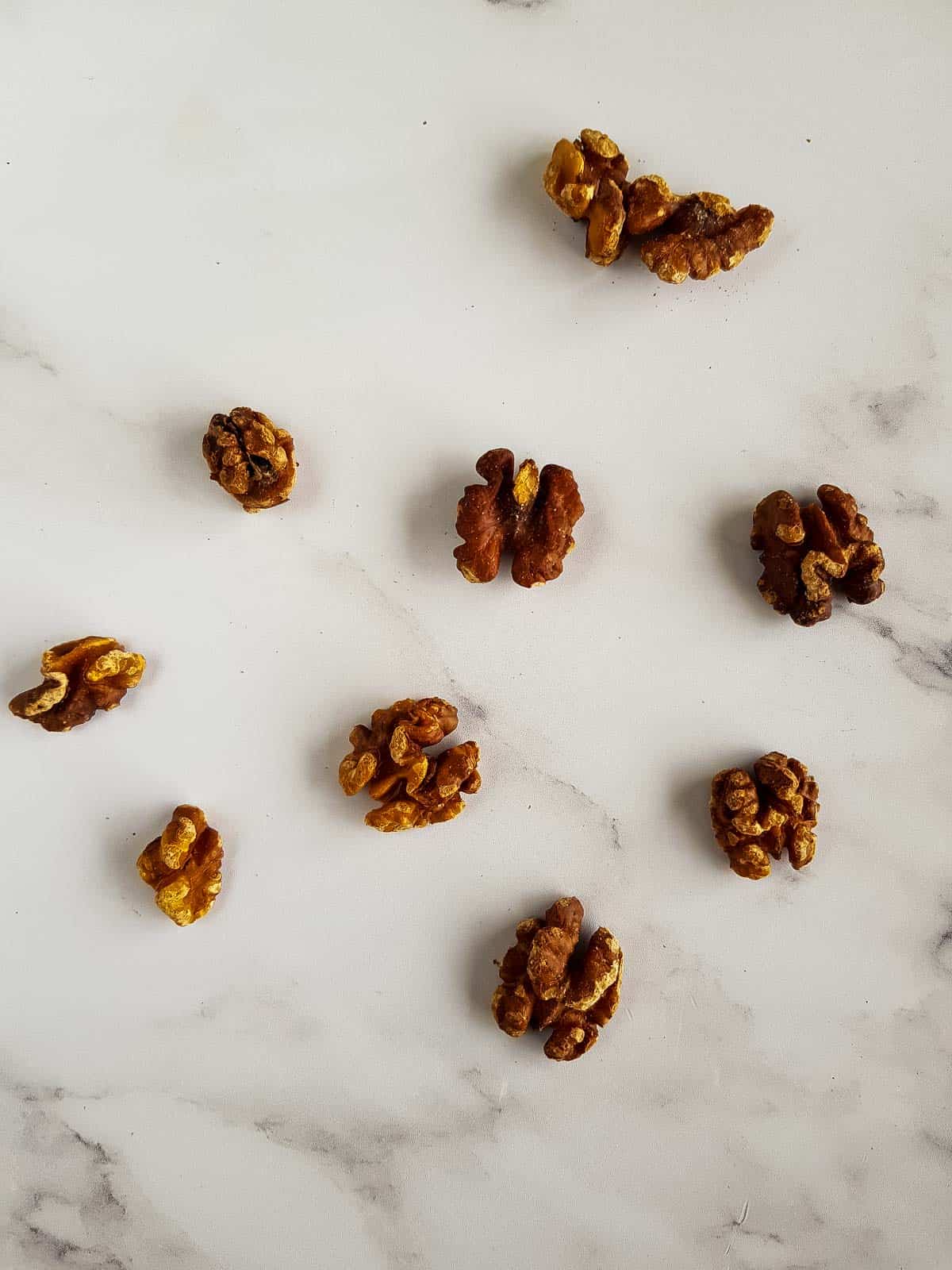 Roasted walnuts scattered on a table.