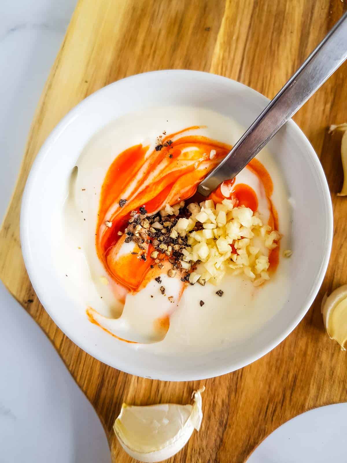 Sriracha aioli being made in a bowl.