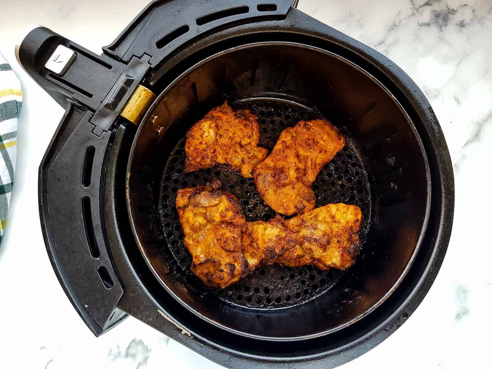 Chicken thighs in an air fryer.