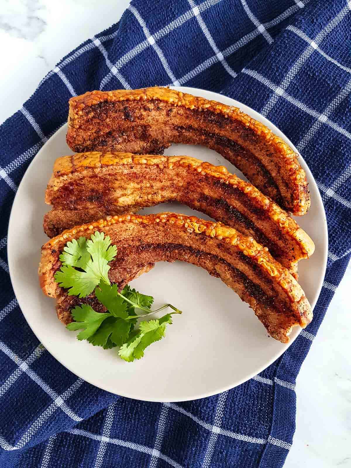 Air fried pork belly slices on a plate.