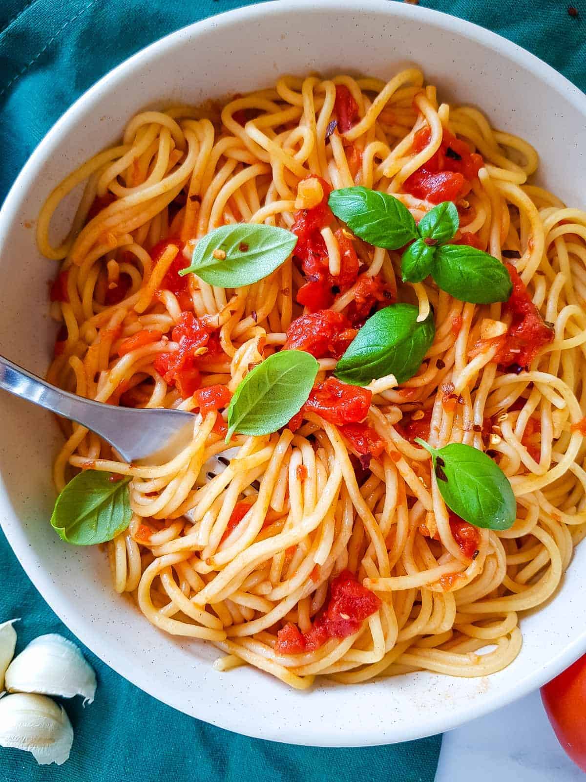 Bowl of spaghetti arrabbiata with a fork in it.