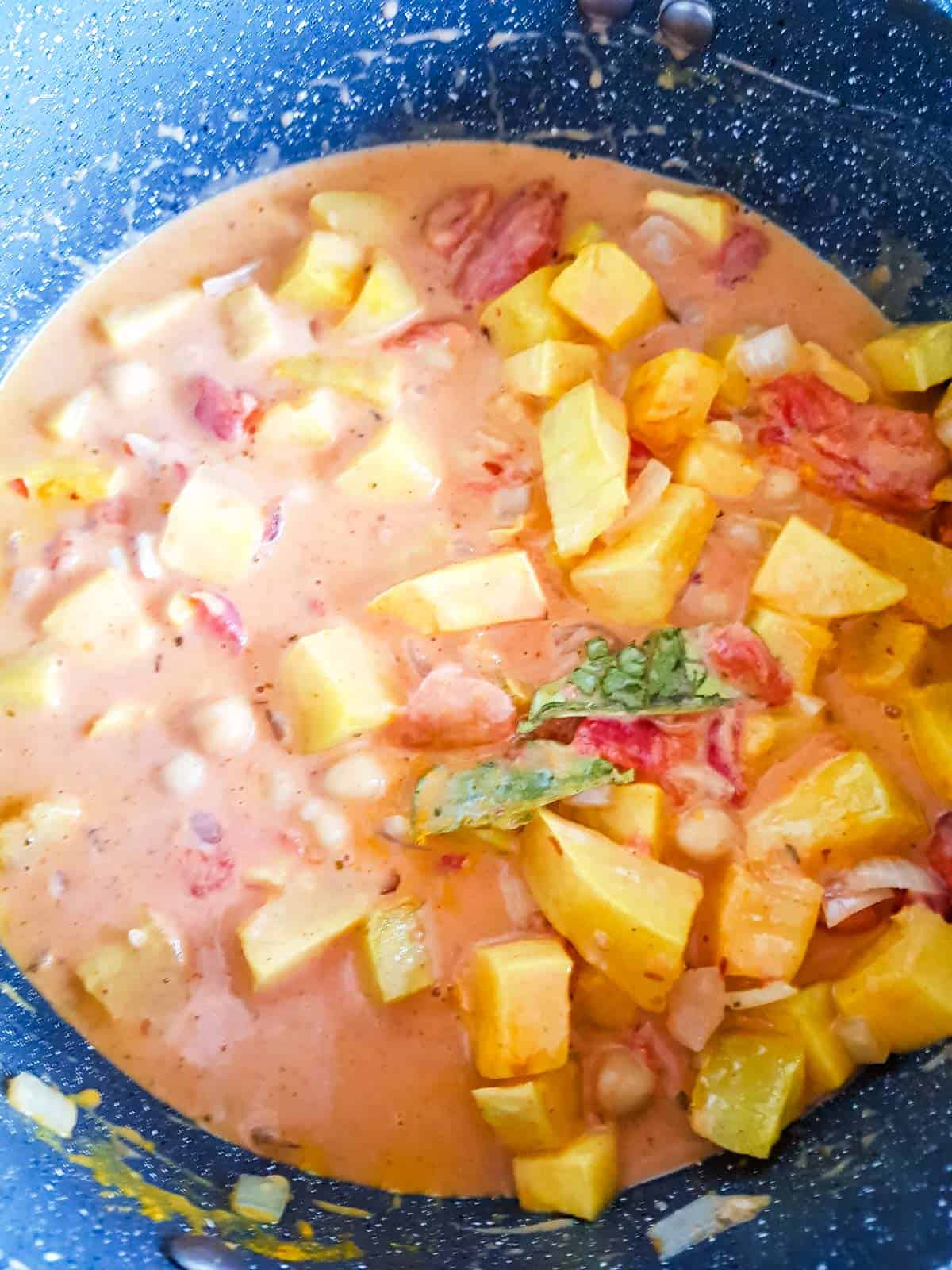 Butternut squash curry cooking in a pot.