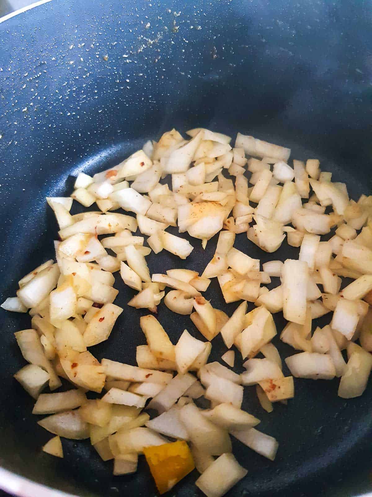 Sauteeing onion, garlic and ginger in a pot.