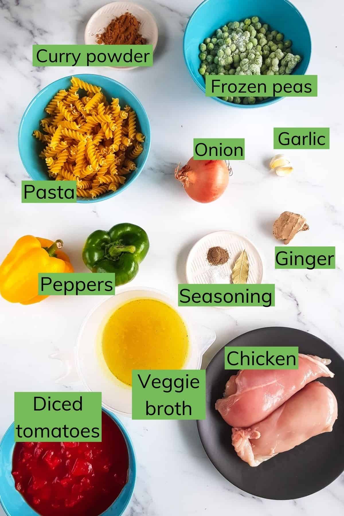 Ingredients required to make chicken curry pasta laid out on a table.