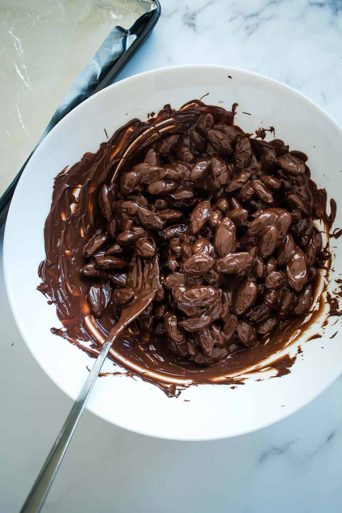 Melted chocolate and almonds in a bowl.