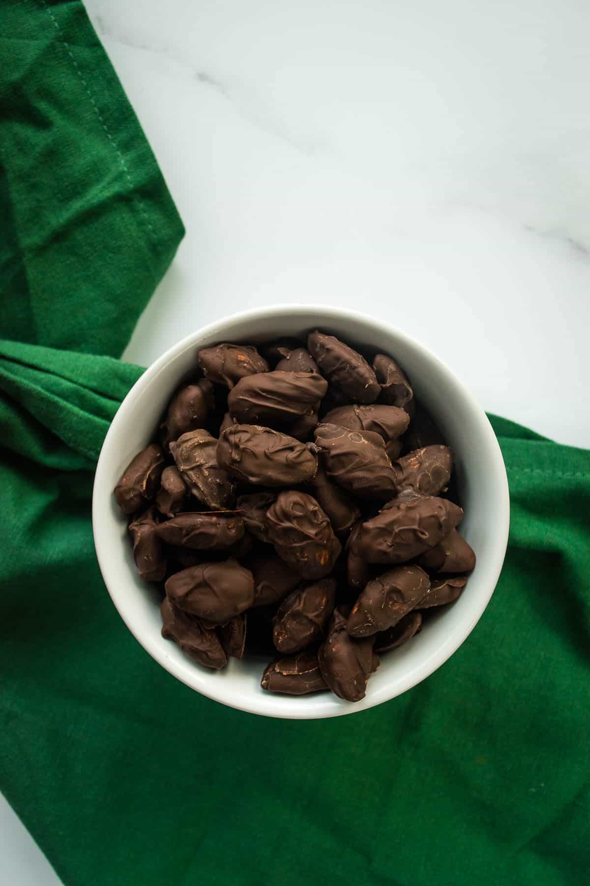 Dark chocolate almonds in a bowl.