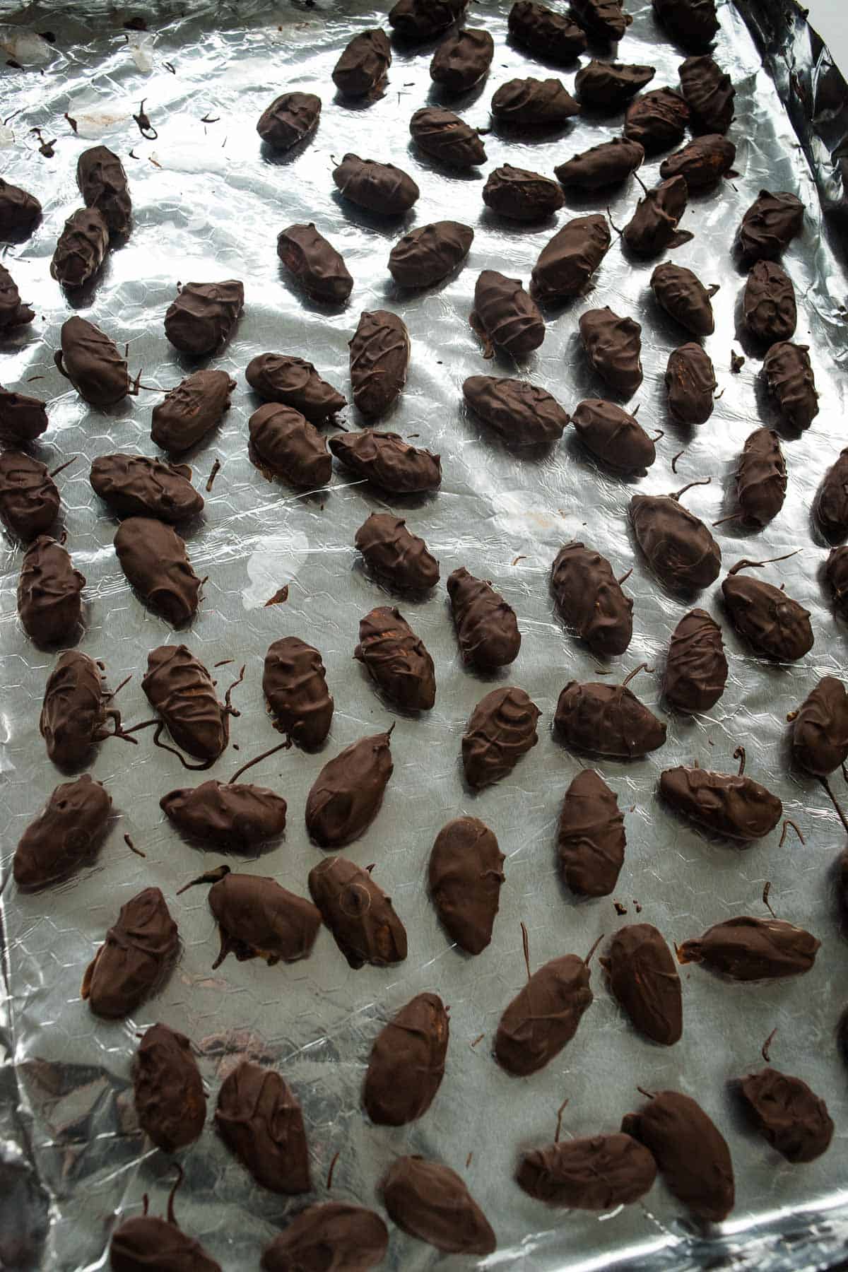 Chocolate coated almonds on foil.