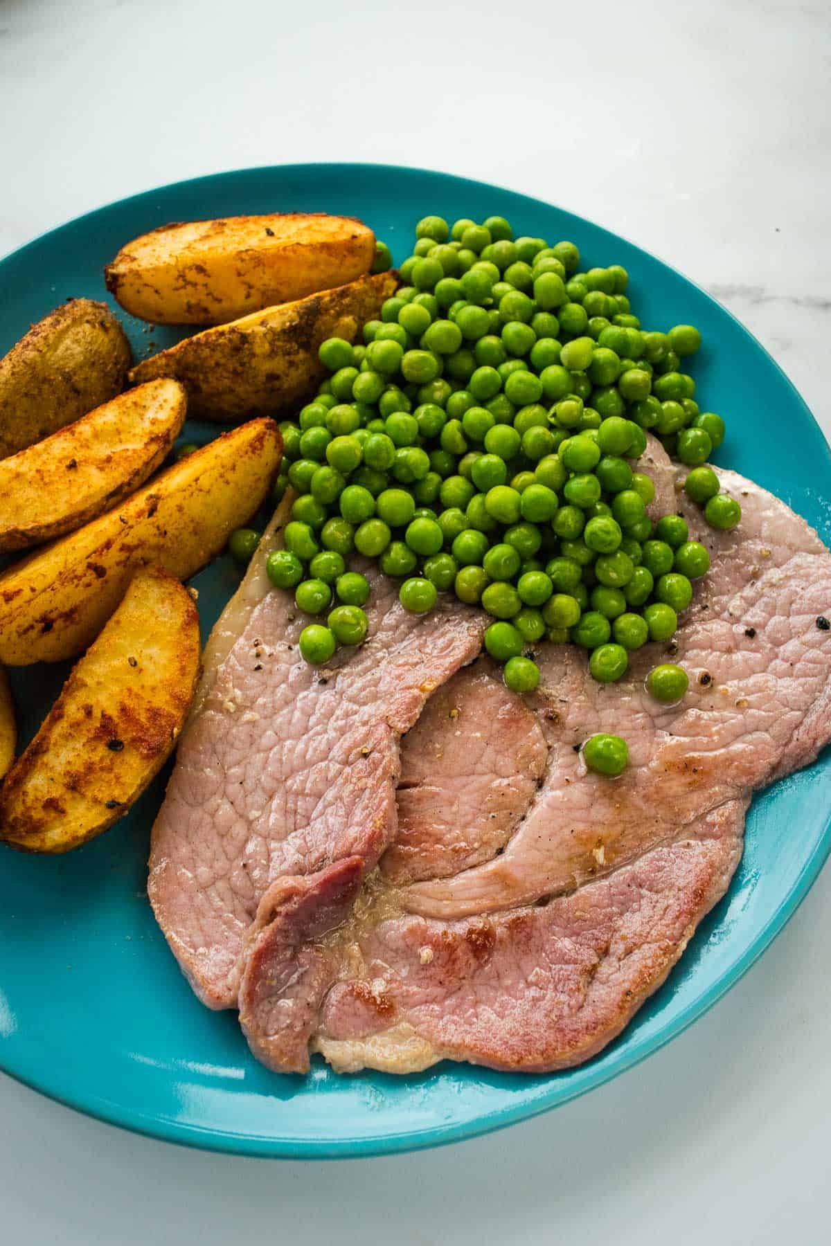 Plated ham steaks with side dishes.