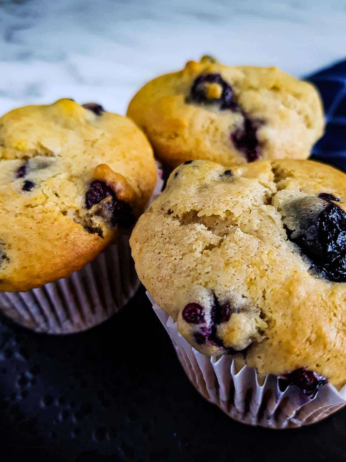 Close up of three healthy lemon blueberry muffins.