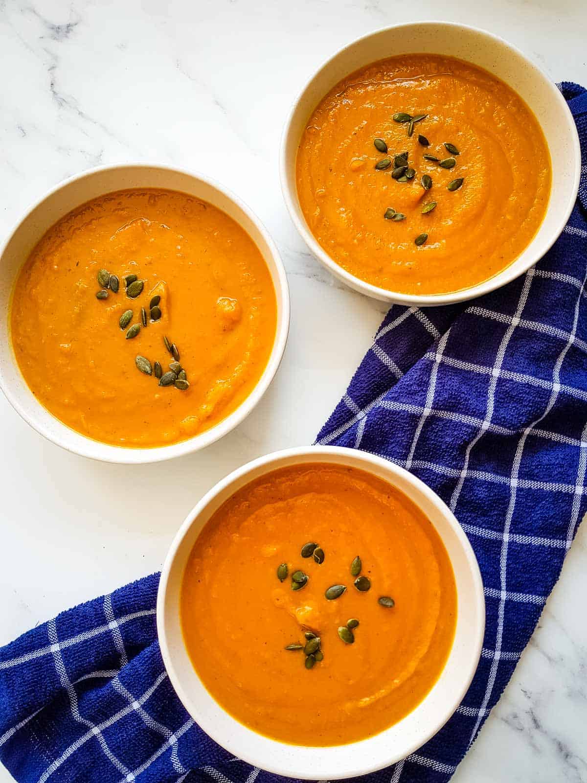 Three bowls of Pumpkin and Sweet Potato Soup.