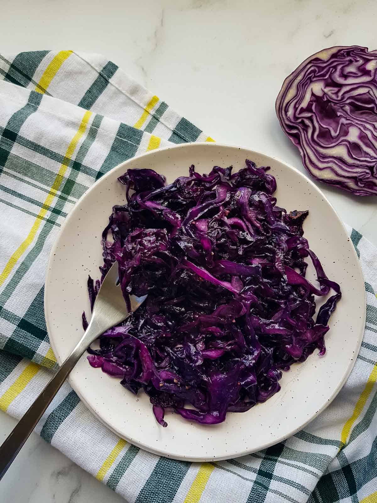 Braised red cabbage on a plate with a fork.