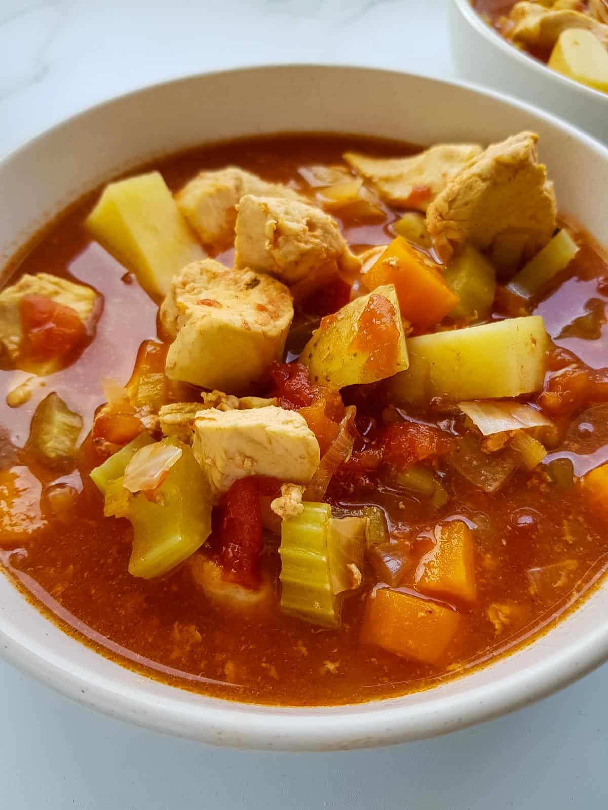 Close up of chicken and potato stew in a bowl.