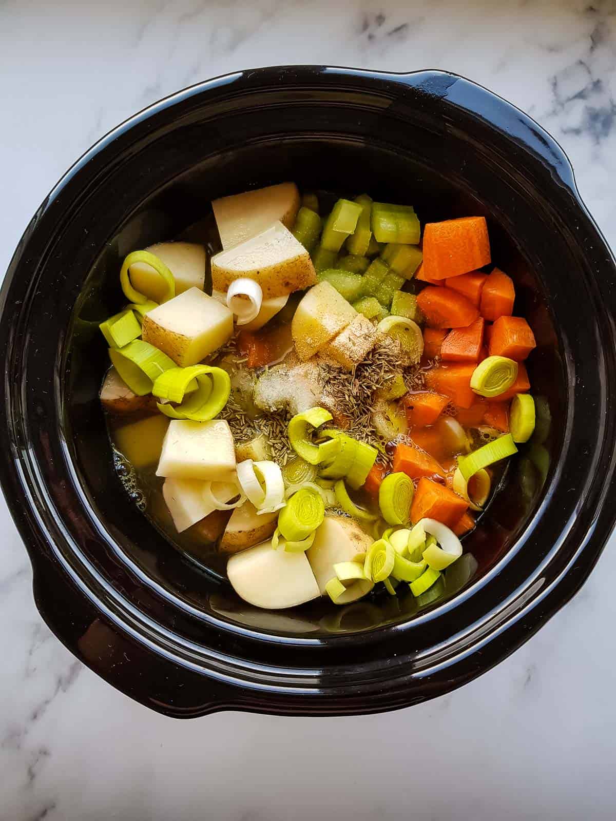 Stew ingredients in a slow cooker.
