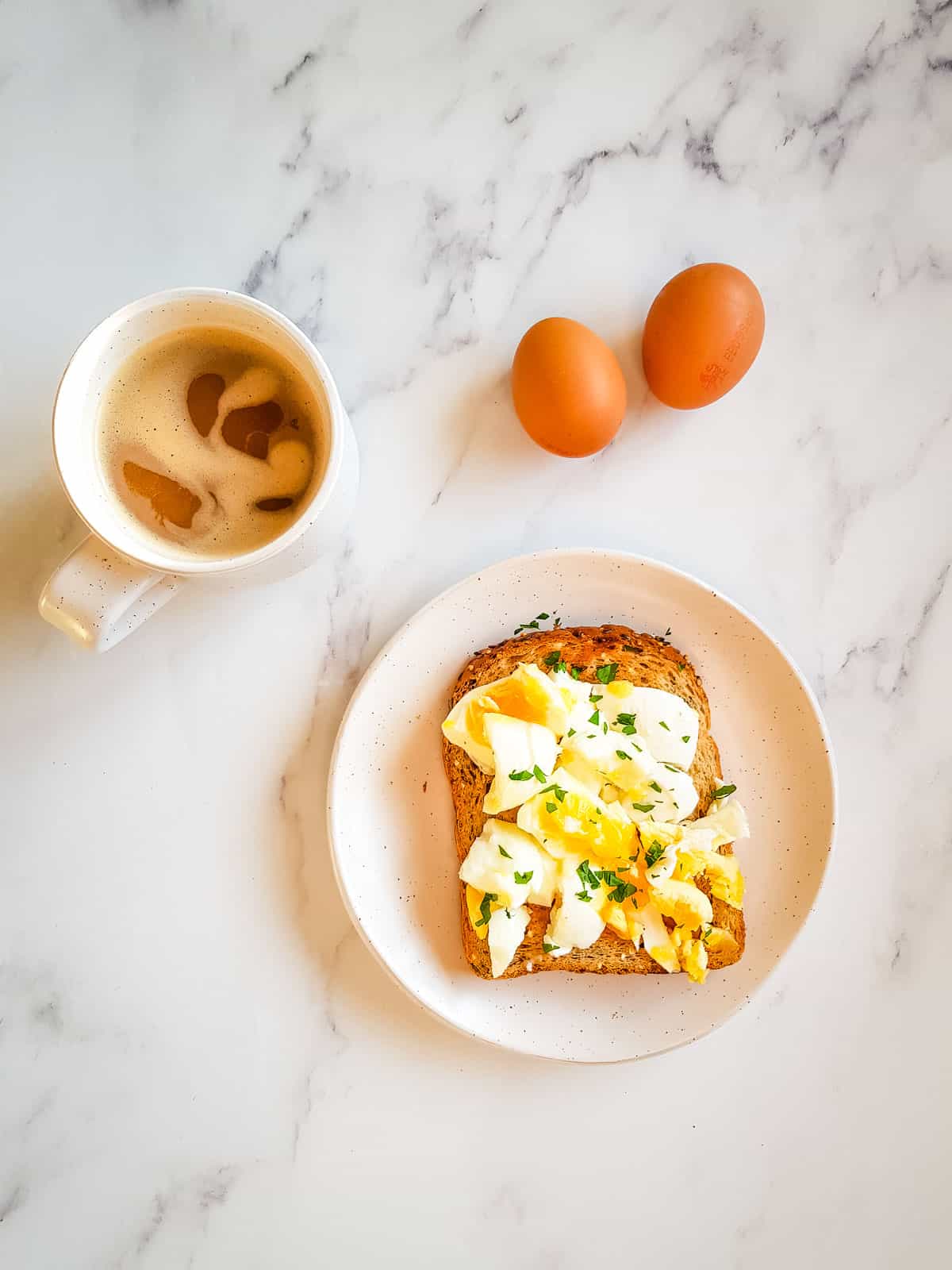 Smashed egg on toast with a cup of coffee.