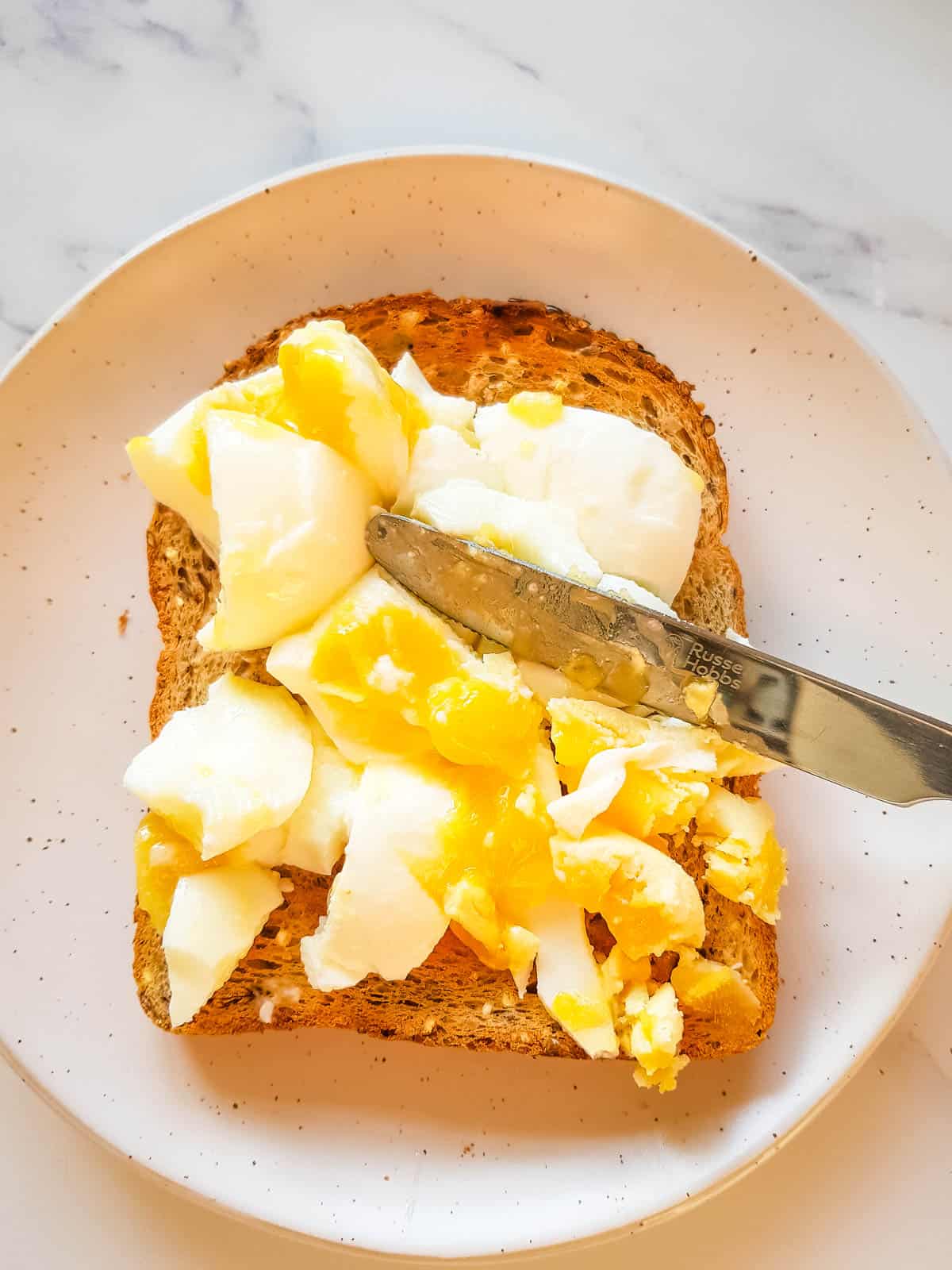 Smashing an egg on toast.