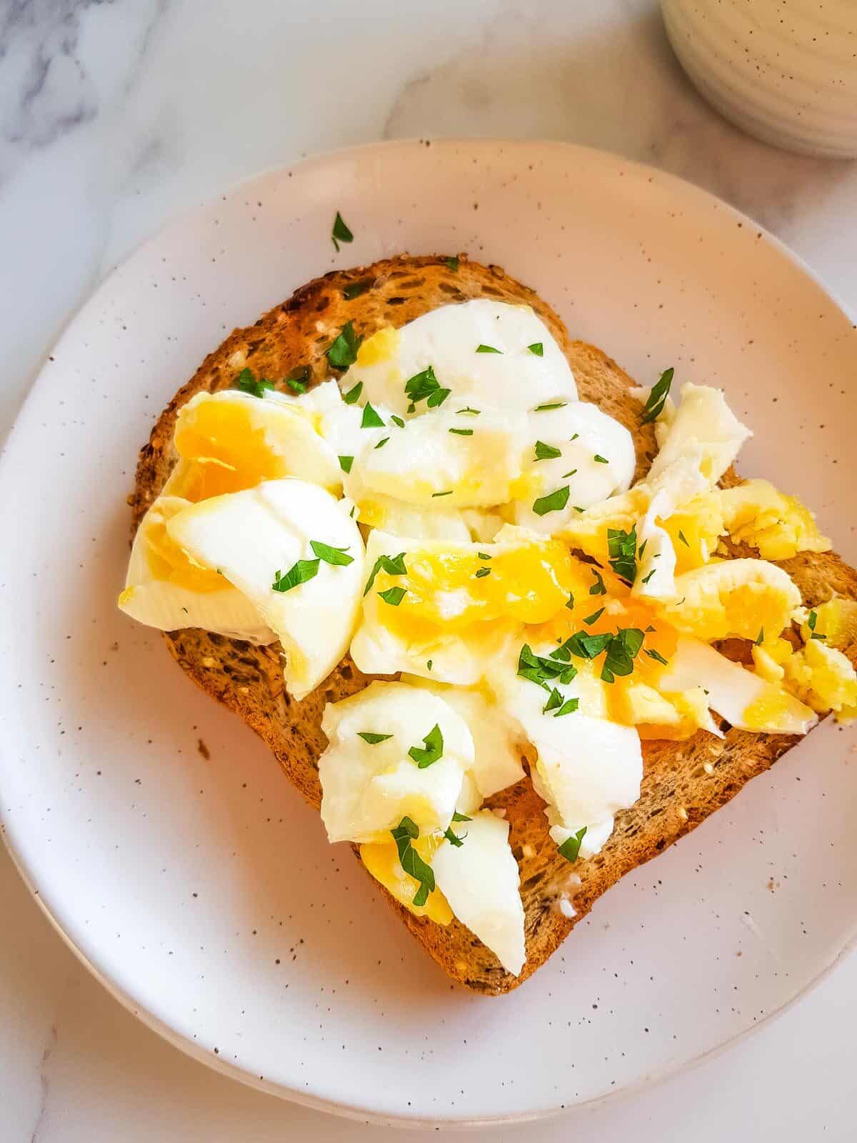 Smashed egg on toast with parsley.