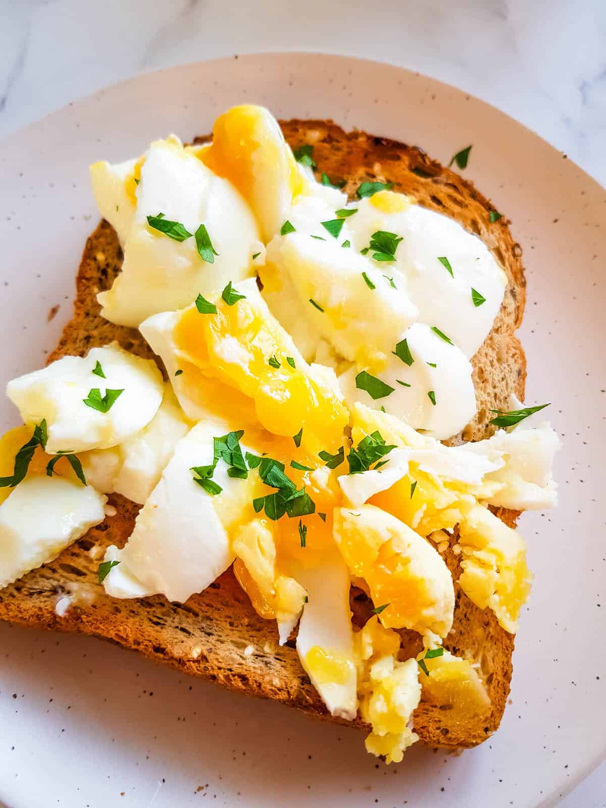 Toast with smashed egg and parsley.