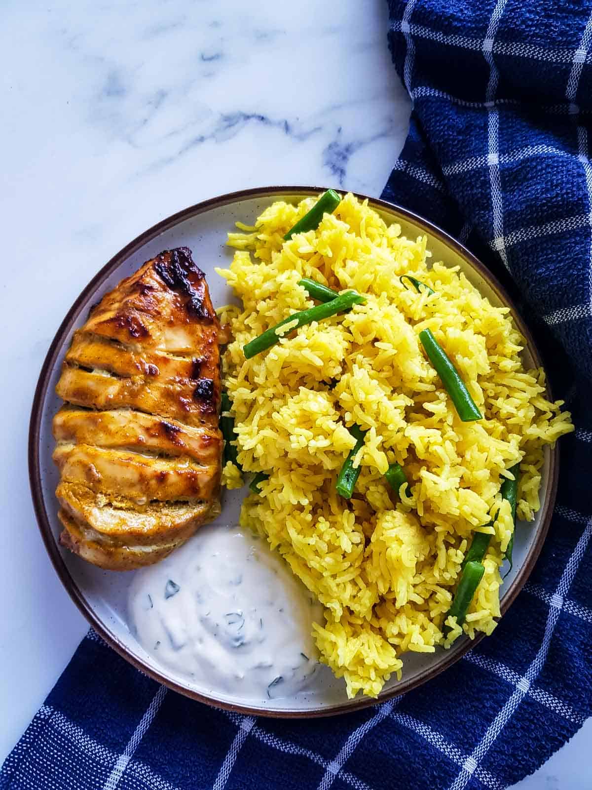 Tandoori Hasselback Chicken with turmeric rice and yogurt sauce.