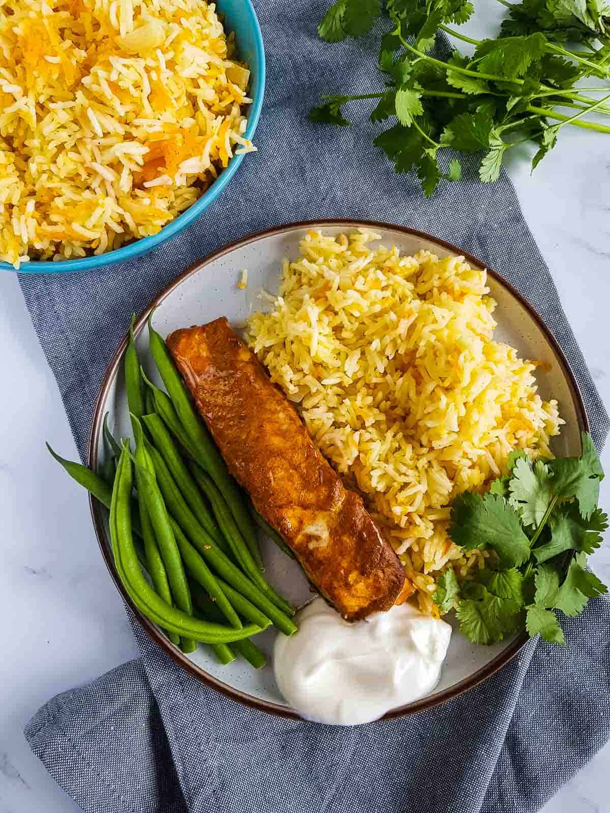 A dinner plate with tandoori marinated salmon.