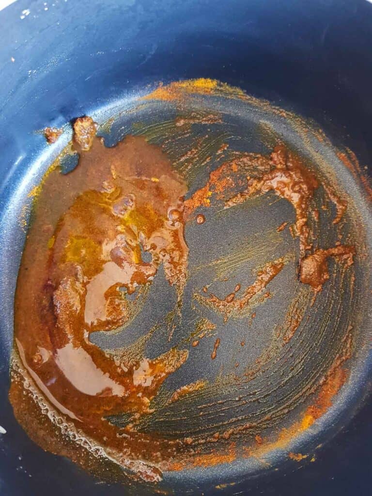 Oil and spices in a pot.