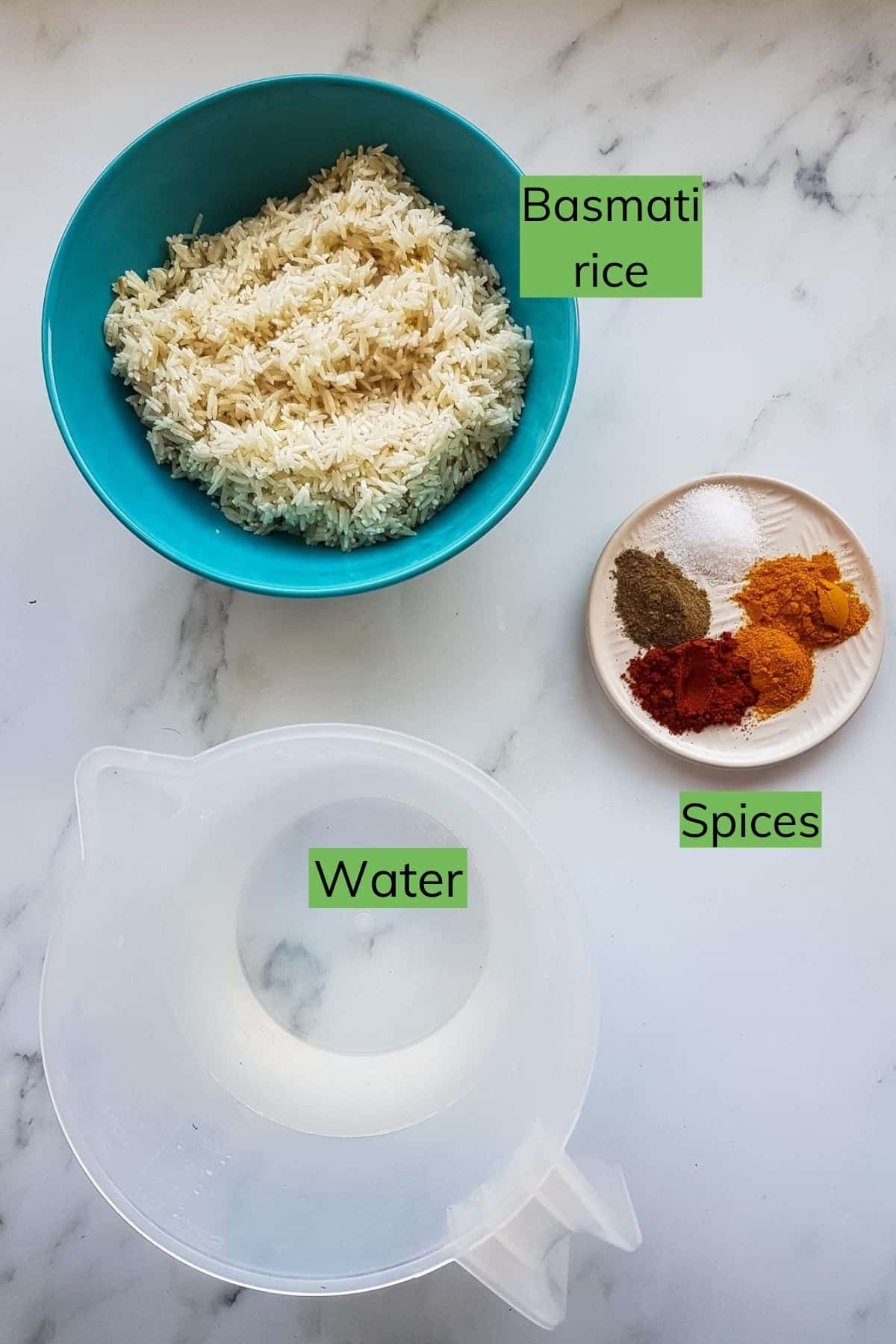 Water, rice and spices laid out on a table.