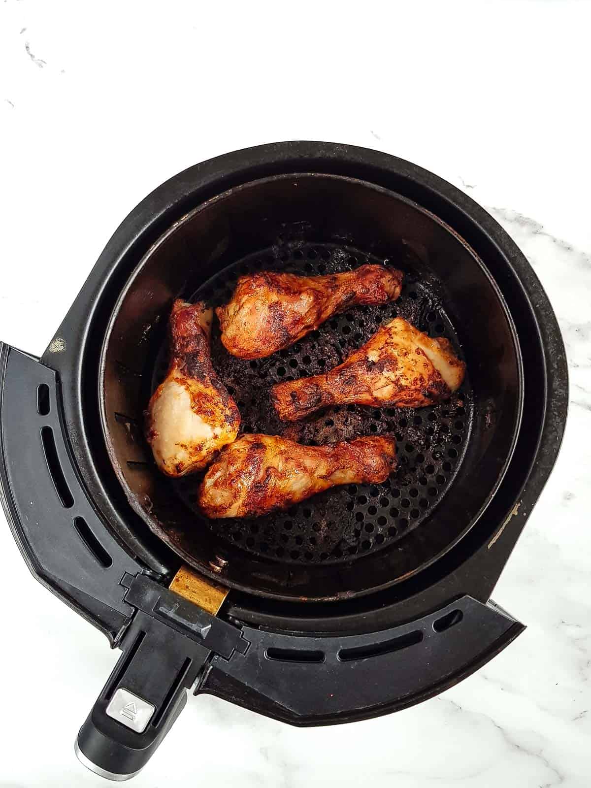 Roasted drumsticks in an air fryer.