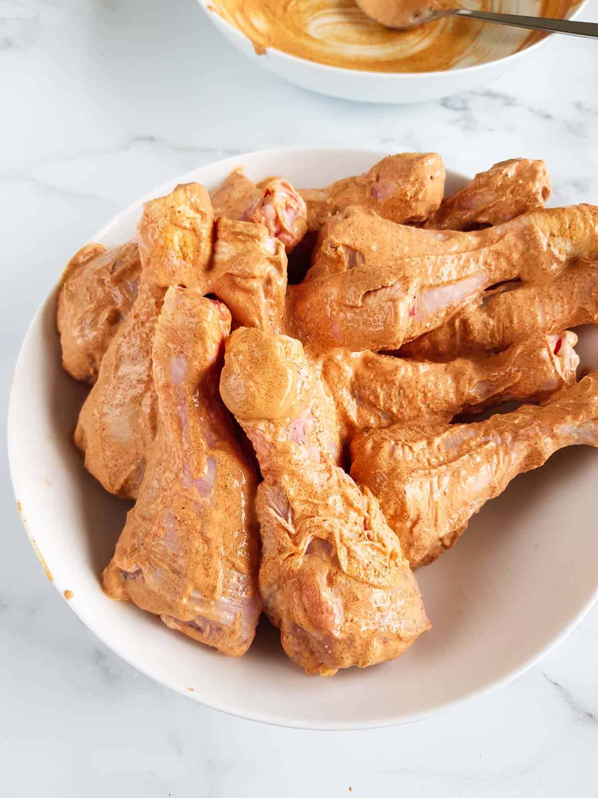 Marinated raw chicken drumsticks.