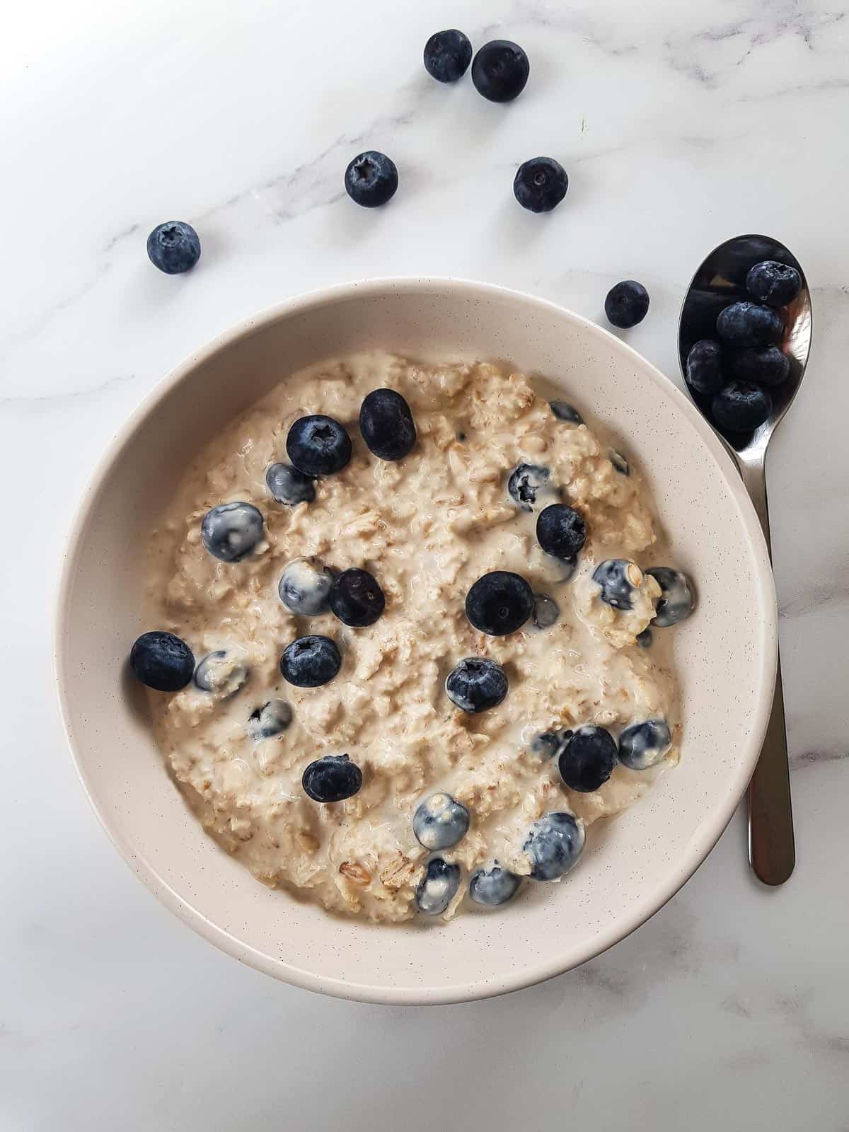 Blueberry overnight oats in a bowl, topped with blueberries.