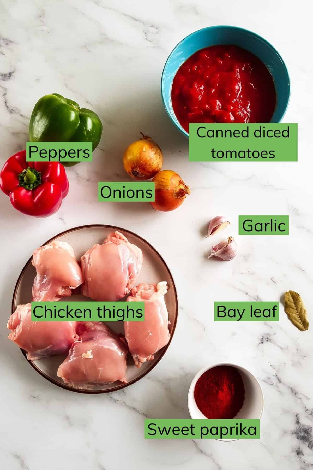 The ingredients needed to make chicken goulash laid out on a table.