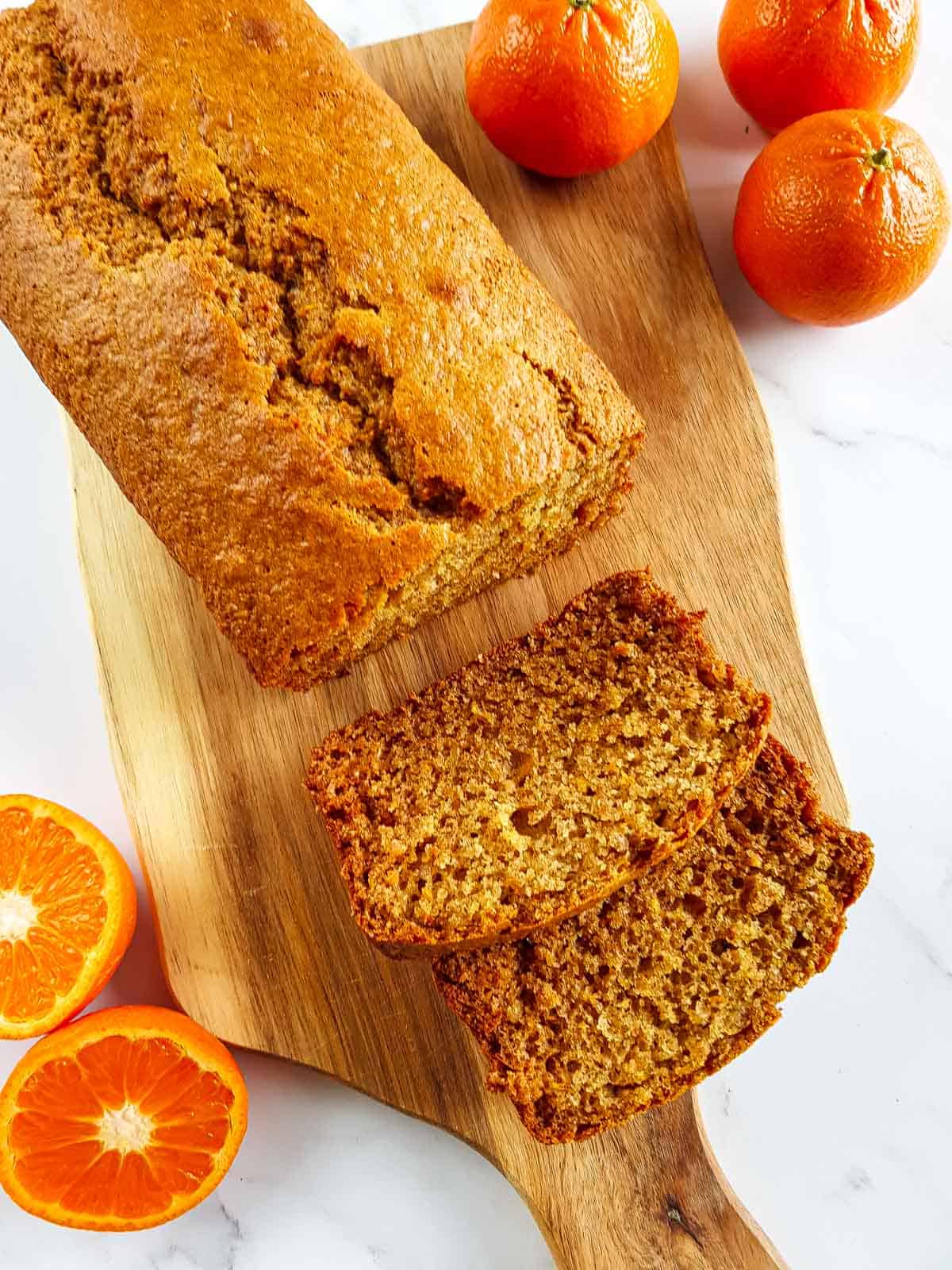 Orange loaf cake on a wooden board.