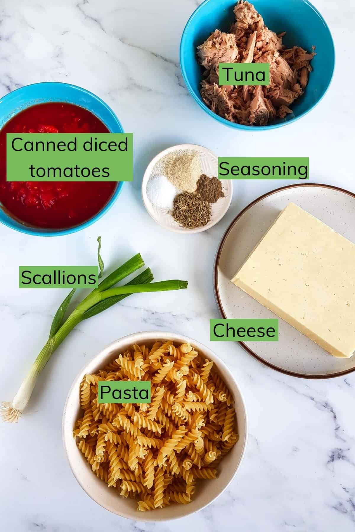 Ingredients to make a tuna pasta bake laid out on a table.