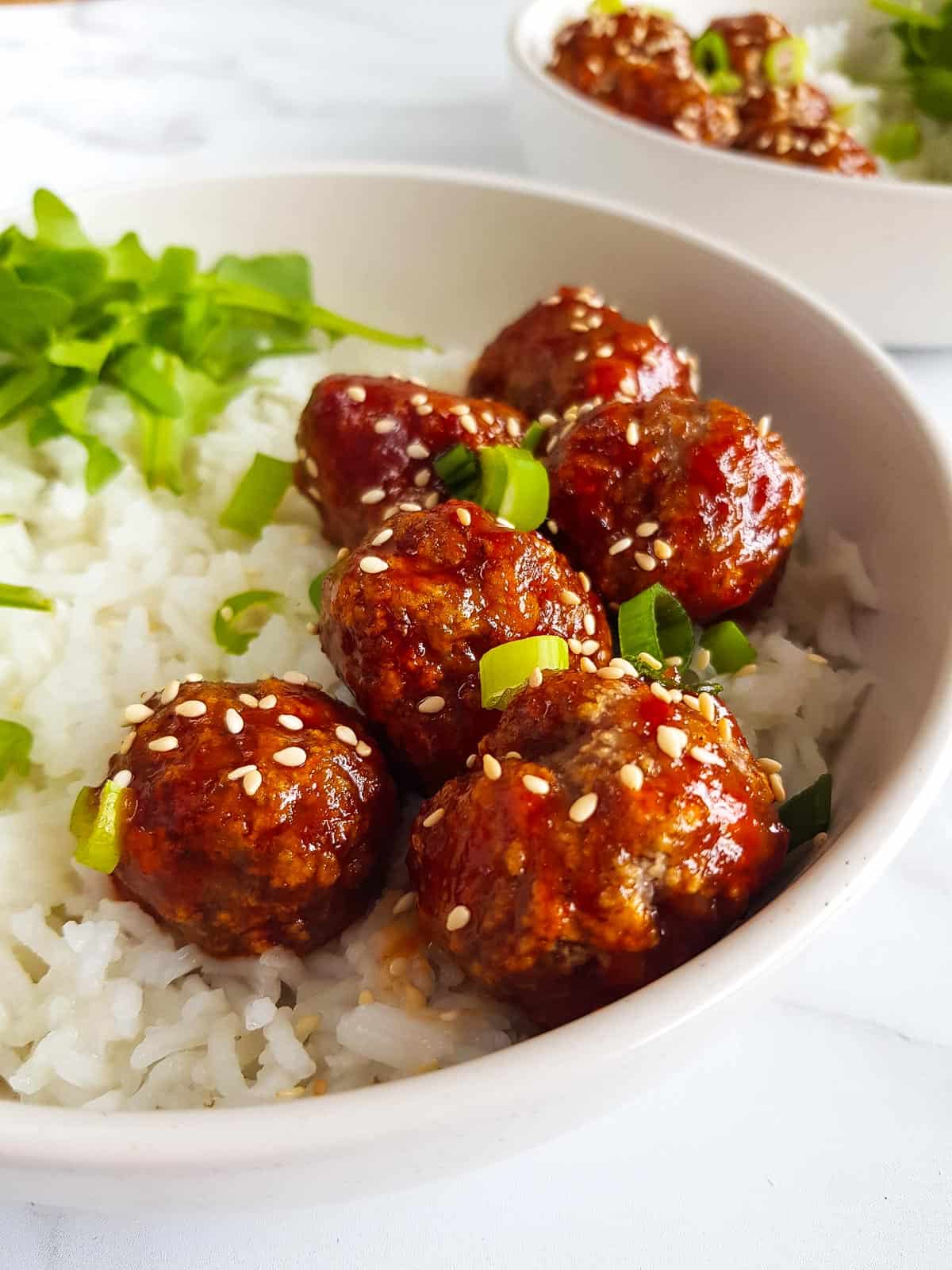 A bowl of honey sriracha meatballs and rice.