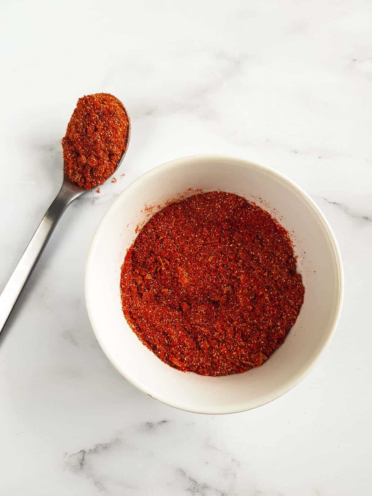 Pork rub in a bowl on a marble table.