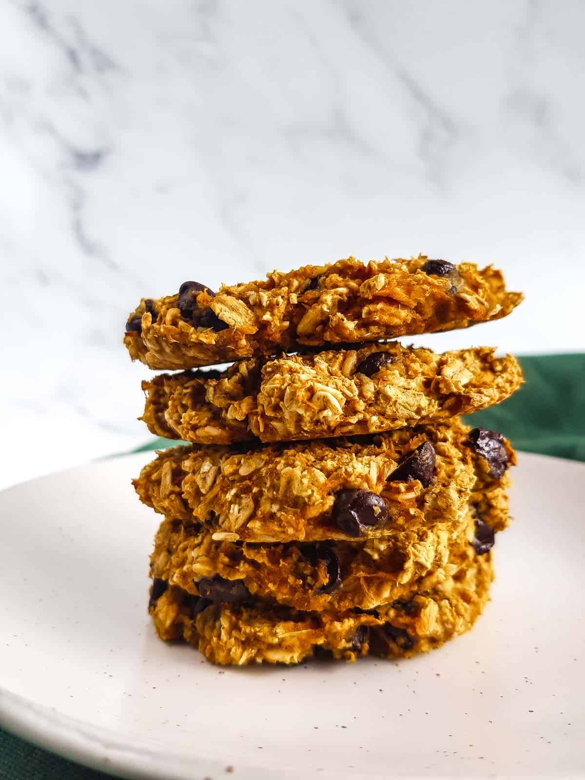 Pumpkin oatmeal cookies stacked on a plate.